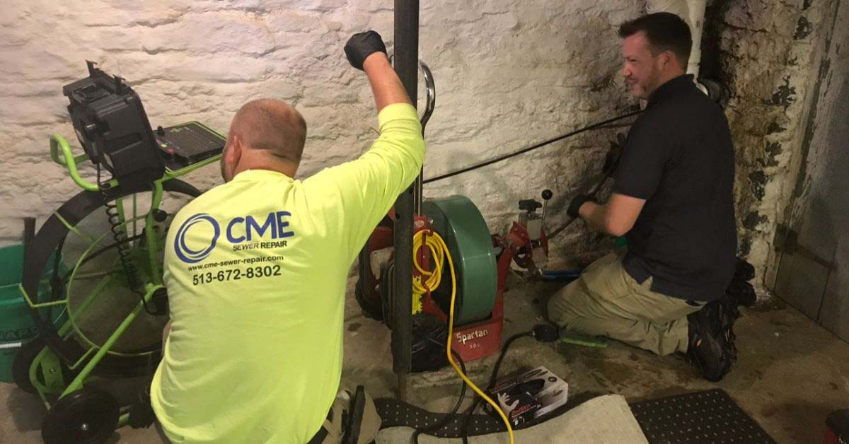 cme technicians performing a free sewer inspection in a basement.